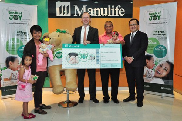 Manulife Philippines President and Chief Executive Officer Ryan Charland (center) and Manulife Philippines Senior Vice President and Alternative Distribution Head Anthony Perez (far right) present  the Presbitero family, winners of a lucky draw with  a trip to Hong Kong Disneyland.